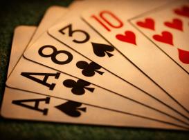 Close-up de cinco cartas em leque sobre pano verde