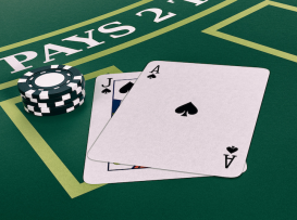 Blackjack com Ás e Valete de espadas sobre mesa de pano verde, com fichas empilhadas ao lado