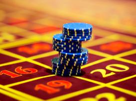 fichas de casino azuis em mesa de roleta vermelha